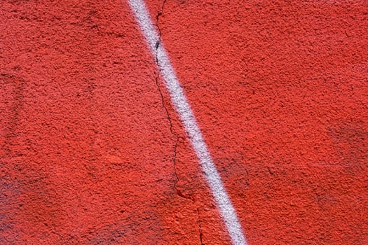 Detail of a red painted wall with white line in the middle