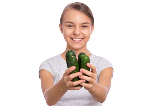 Beautiful young teen girl holding green cucumbers, isolated on white background