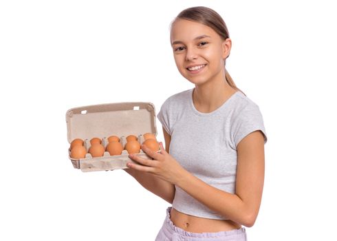 Happy cute teen girl holding brown eggs in box, isolated on white background