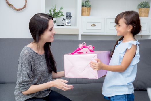 happy of mother and daughter asian with gift with pink ribbon and daughter kissing mother, Happy family concept. Happy mother's day.