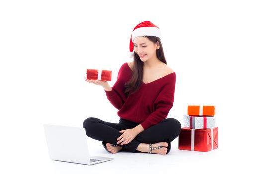 Young woman wear santa hat and gift box sitting labtop with internet shopping in season christmas holiday, girl shoping online on notebook in xmas, celebration concept.
