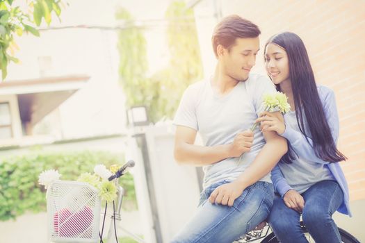 Asian young couple riding on bicycle with happy and fun at the park with romantic love, activity for leisure, relationship concept.