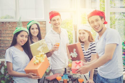 Asian group people man and woman giving gift box and celebration at party outdoor. group of friends social event with birthday achievement, festive concept.