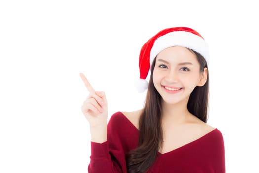 Portrait of beautiful asian young woman pointing something in santa hat smile and happy, girl model isolated on white background, christmas and holiday concept.