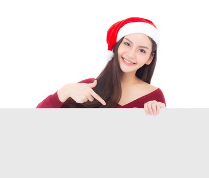 Portrait of beautiful christmas asian young woman in santa hat holding board with copyspace empty isolated on white background, xmas holiday concept.
