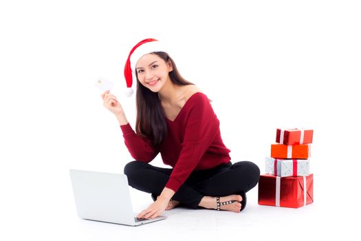 Young woman gift box sitting labtop with internet shopping and holding credit card christmas holiday, girl shoping online on notebook in xmas, celebration concept.