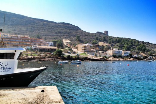 La Azohia, Cartagena, Murcia, Spain- October 1, 2019: Beautiful beach with boats , cliffs and mountains in La Azohia village in Cartagena, Murcia, Spain in a sunny day