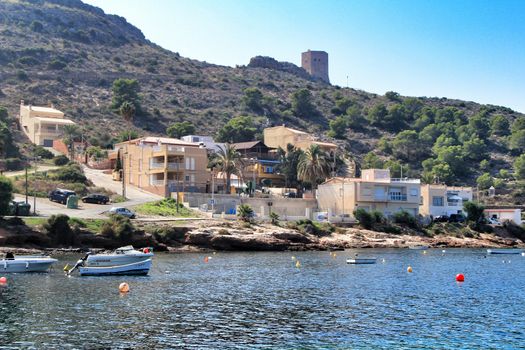 La Azohia, Cartagena, Murcia, Spain- October 1, 2019: Beautiful beach with boats , cliffs and mountains in La Azohia village in Cartagena, Murcia, Spain in a sunny day