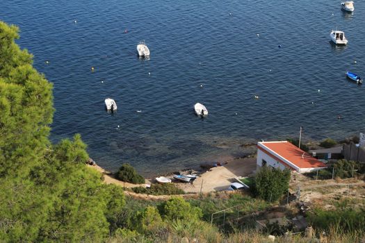 La Azohia, Cartagena, Murcia, Spain- October 2, 2019: Beautiful beach with boats , cliffs and mountains in La Azohia village in Cartagena, Murcia, Spain in a sunny day. Views from Santa Elena tower viewpoint.