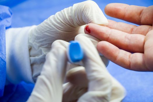 Insulin testing process, blood test and syringe. Injection in the hand. Patients and doctor. Studio shoot.