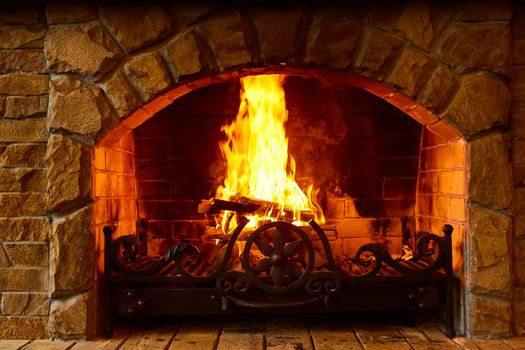 Warm cozy fireplace with real wood burning in it. Cozy winter concept. Christmas and travel background with space for your text