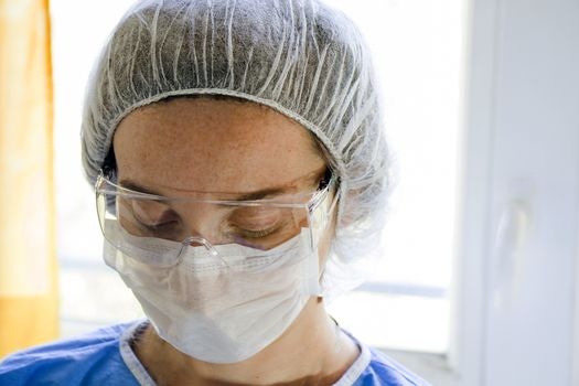 Woman doctors portrait, young girl doctors face with mask and safety glass uniform. Uniform for surgery and viruses. close-up.