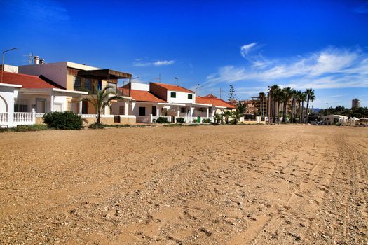 Mazarron, Murcia, Spain- October 3, 2019: Beautiful Bahia beach in a sunny and clear day in Mazarron, Murcia, Spain. Small houses in the background.