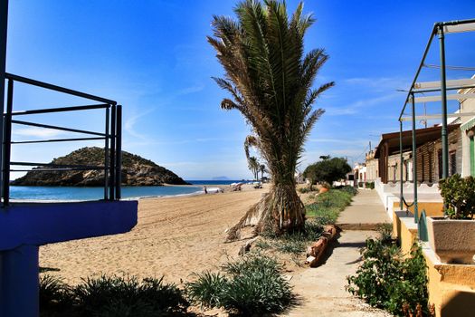 Mazarron, Murcia, Spain- October 3, 2019: Beautiful Bahia beach in a sunny and clear day in Mazarron, Murcia, Spain. Small houses on the shore.