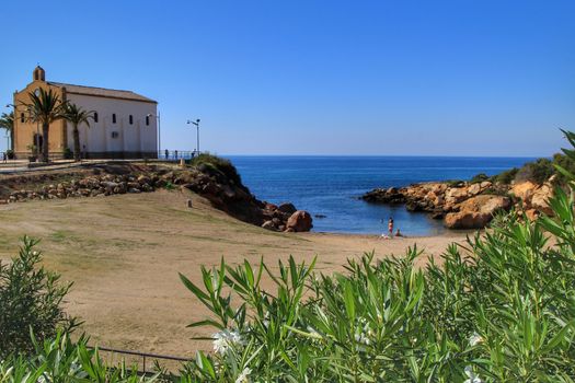 Isla Plana, Murcia, Spain- October 3, 2019: Old Virgen del Carmen hermitage built on the edge of a cliff in a cove in Isla Plana village, Cartagena, Spain