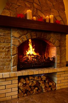 Warm cozy fireplace with real wood burning in it. Cozy winter concept. Christmas and travel background with space for your text