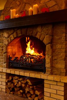 Warm cozy fireplace with real wood burning in it. Cozy winter concept. Christmas and travel background with space for your text