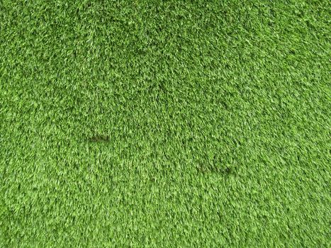 Artificial greener grass backdrop close up photo.