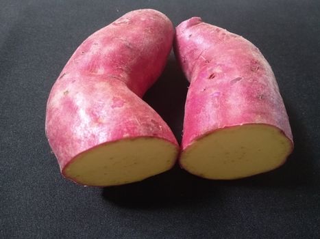 sweet pink potatoes on the black background close up photo