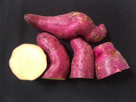 sweet pink potatoes on the black background close up photo