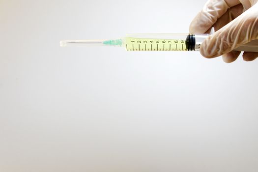 Medical needle and doctors hand with glove on the white background, corona virus or covid-19 vaccine in needle. Studio shoot.