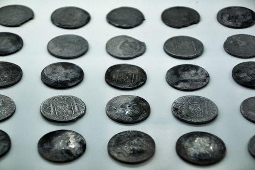 Cartagena, Murcia, Spain- July 25, 2019: Spanish silver coins recovered from the ocean floor by the Odissey company and exposed in underwater museum in Cartagena, Spain