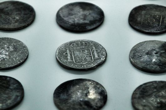 Cartagena, Murcia, Spain- July 25, 2019: Spanish silver coins recovered from the ocean floor by the Odissey company and exposed in underwater museum in Cartagena, Spain