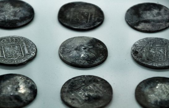 Cartagena, Murcia, Spain- July 25, 2019: Spanish silver coins recovered from the ocean floor by the Odissey company and exposed in underwater museum in Cartagena, Spain