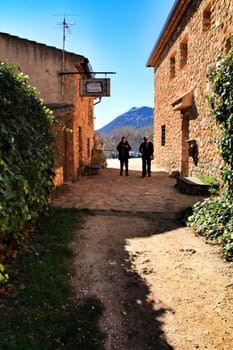 Riopar Viejo, Albacete, Spain- February 8, 2019: Tourists visiting and walking through cobbled stone streets in Riopar Viejo village, Castilla La Mancha, Spain. Sunny day of winter.