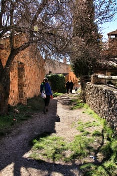 Riopar Viejo, Albacete, Spain- February 8, 2019: Tourists visiting and walking through cobbled stone streets in Riopar Viejo village, Castilla La Mancha, Spain. Sunny day of winter.