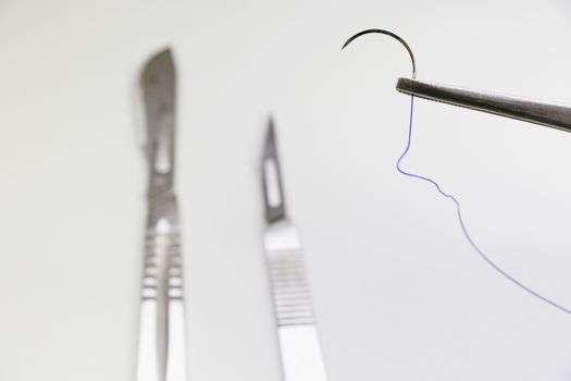 Dissection Kit - Absorbable suture, polyglycolic acid. Surgery operation equipment, knife, needle and suture. Studio shoot.