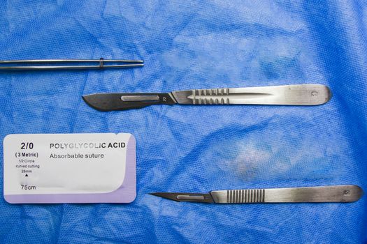 Tbilisi, Georgia - July 22, 2020: Dissection Kit - Absorbable suture, polyglycolic acid. Surgery operation equipment, knife, needle and suture. Studio shoot.