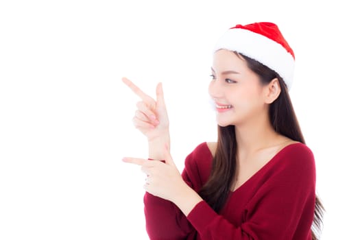 Portrait of beautiful asian young woman pointing something in santa hat smile and happy, girl model isolated on white background, christmas and holiday concept.