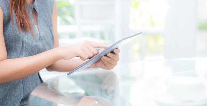 Closeup view of woman holding digital tablet on touch screen device working internet online or open email at office, communication and social networking concept.