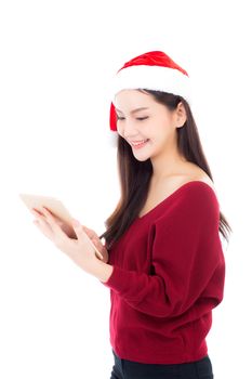 Beautiful young asian woman in red dress with christmas hat holding tablet isolated on white background, girl with connection digital, communication concept.