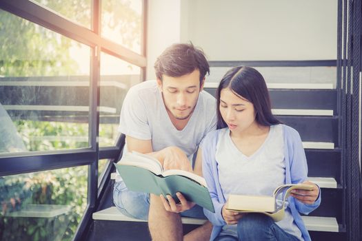 Couple asian handsome man and beautiful woman reading book and smile at home, boyfriend and girlfriend with activities together for leisure, education concept.