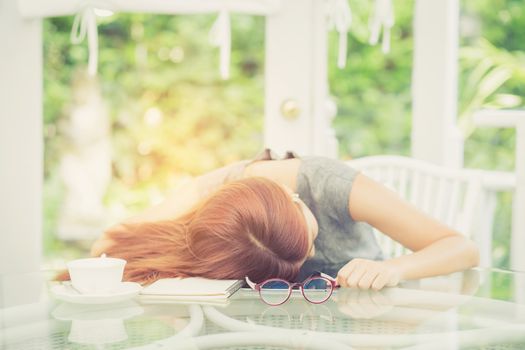 Workhard young asian woman tried and sleep on desk in the garden, girl work overload, business concept.