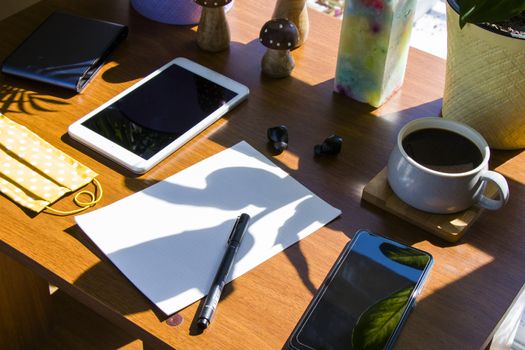 Working in office, workspace with notebook and mobile phone, coffee and plants, workplace.