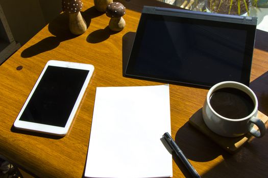 Working in office, workspace with notebook and mobile phone, coffee and plants, workplace.