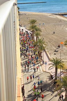 Santa Pola, Spain- January 21, 2018: Runners in the Half Marathon of the fishing village of Santa Pola, province of Alicante, on a sunny day in January