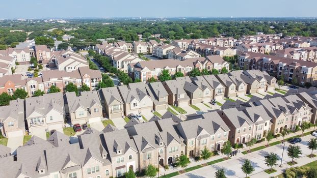 Aerial view of brand new two story condo and townhomes in downtown Flower Mound, Texas, America. Master-planned community and census-designated residential houses and apartment buildings