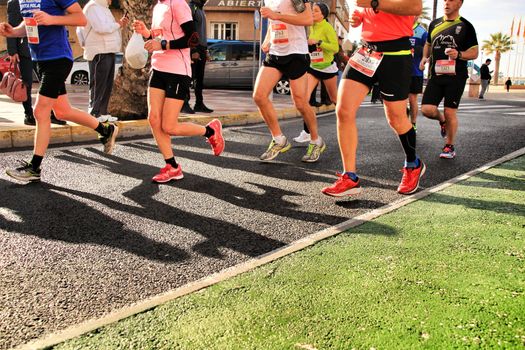 Santa Pola, Spain- January 20, 2019: Runners in the Half Marathon of the fishing village of Santa Pola, province of Alicante, on a sunny day in January
