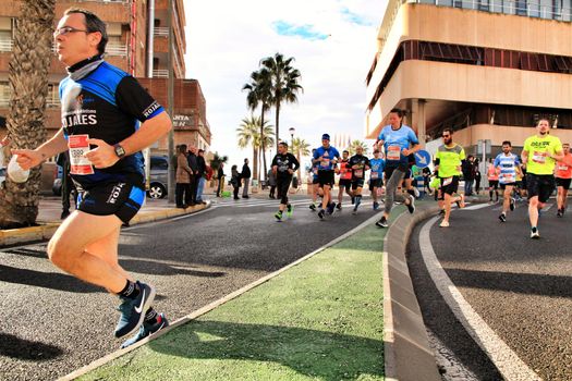 Santa Pola, Spain- January 20, 2019: Runners in the Half Marathon of the fishing village of Santa Pola, province of Alicante, on a sunny day in January