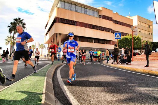 Santa Pola, Spain- January 20, 2019: Runners in the Half Marathon of the fishing village of Santa Pola, province of Alicante, on a sunny day in January