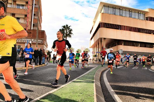Santa Pola, Spain- January 20, 2019: Runners in the Half Marathon of the fishing village of Santa Pola, province of Alicante, on a sunny day in January