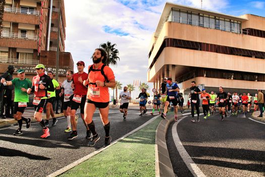 Santa Pola, Spain- January 20, 2019: Runners in the Half Marathon of the fishing village of Santa Pola, province of Alicante, on a sunny day in January