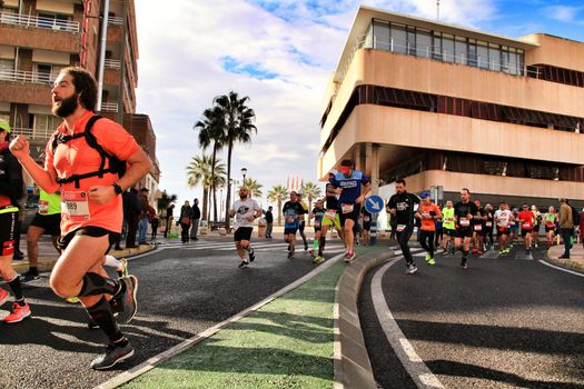 Santa Pola, Spain- January 20, 2019: Runners in the Half Marathon of the fishing village of Santa Pola, province of Alicante, on a sunny day in January