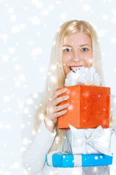 Happy woman holding Christmas gifts, silver background and snow glitter with copyspace, shopping and holidays