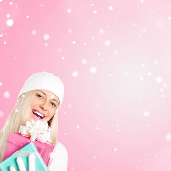 Happy woman holding Christmas gifts, pink background and snow glitter with copyspace, shopping and holidays