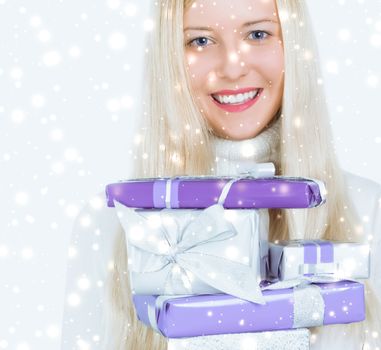 Happy woman holding Christmas gifts, silver background and snow glitter with copyspace, shopping and holidays